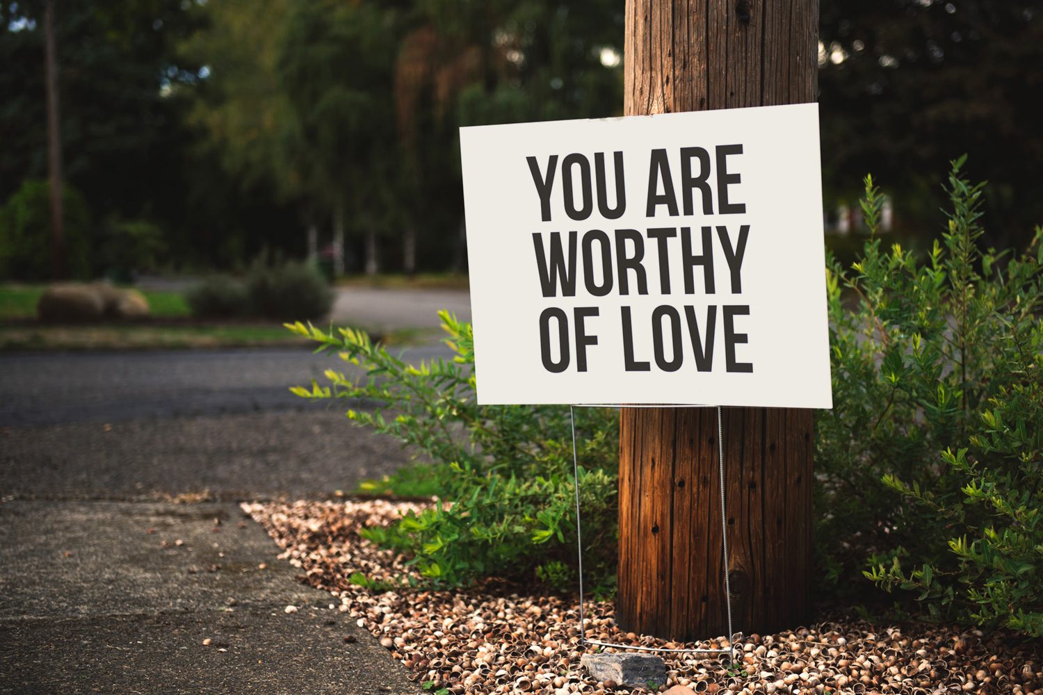 Self-Care Sign in a garden saying you are worthy of love